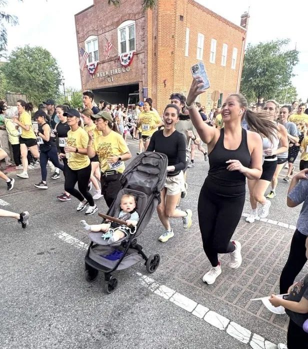 Runners and a stroller passing the Pioneer Fire Company at the Jenkintown Sunset 5K