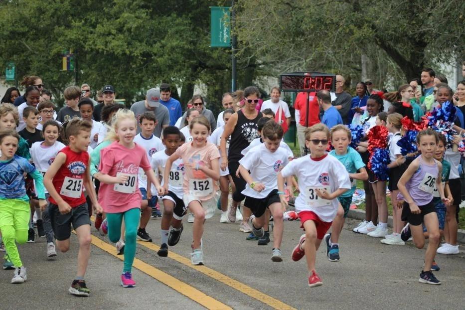 Kids and families at the Read Write Run 5K start line, race clock reading 0:02
