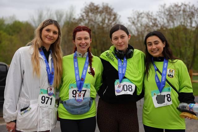 Four finishers wearing medals after a 5K
