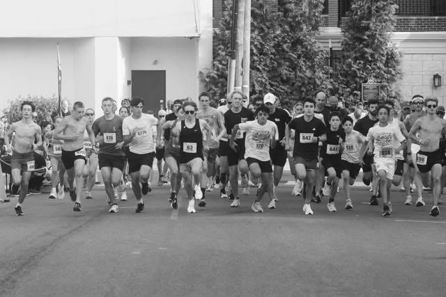 The front pack sprinting off the start line, in black and white