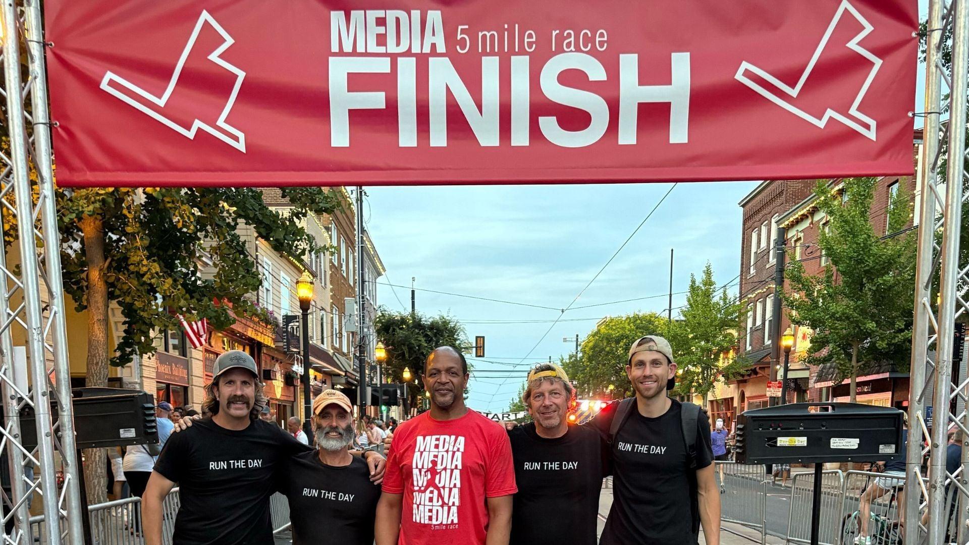 Volunteers timing a 5K race with smartphones at the finish line